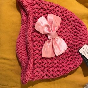 Pink beanie with ribbon in shape of bow.